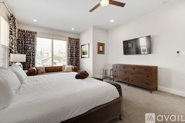 A bedroom with a large bed, a dresser, and a television.