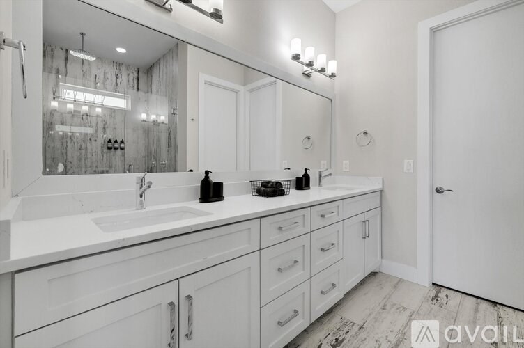 A bathroom with a white sink and a large mirror above it.