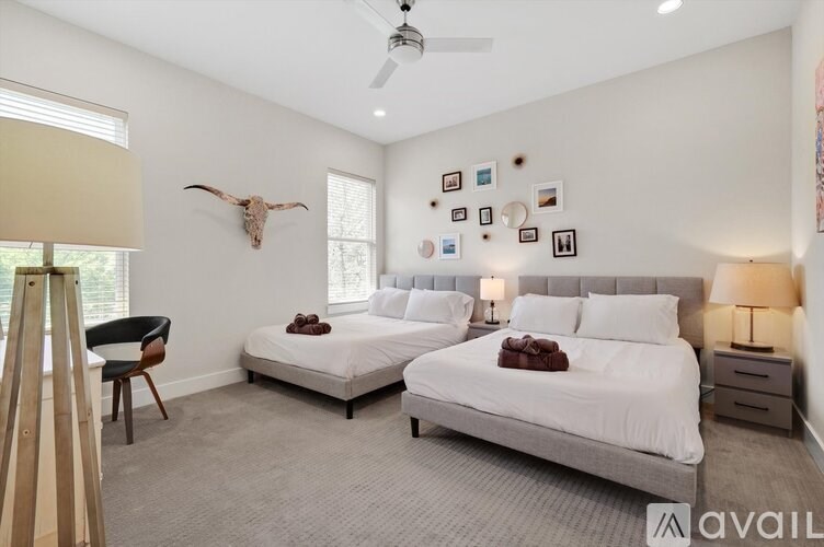 A bedroom with two beds and a cow skull on the wall.