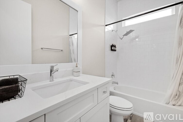 A white bathroom with a sink, toilet, and bathtub.