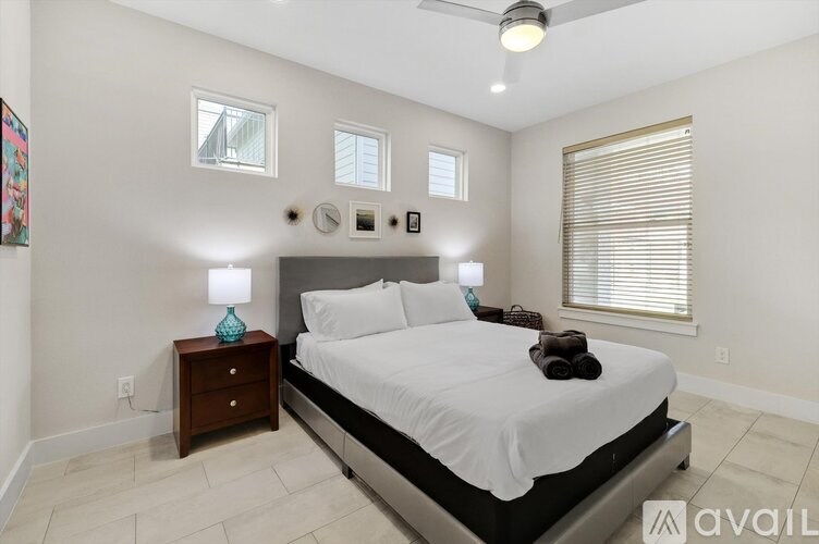 A bedroom with a bed, nightstand, and a ceiling fan.