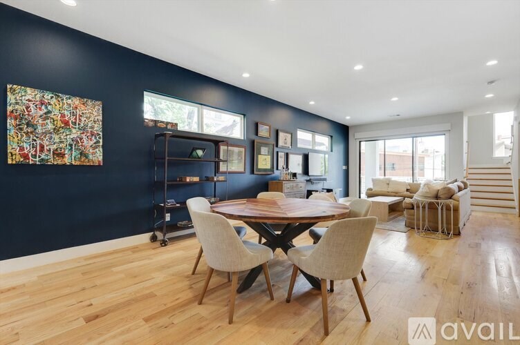 A dining room with a wooden table and chairs.