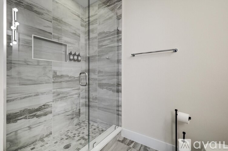 A bathroom with a marble tile shower and a towel bar.