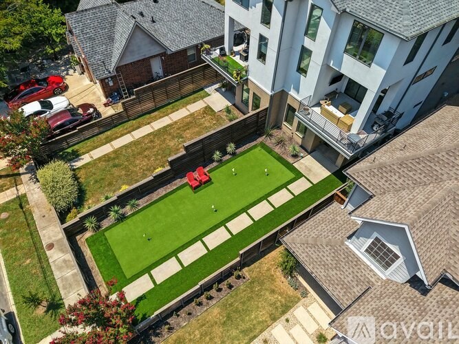 A backyard with a lawn and a red bench.