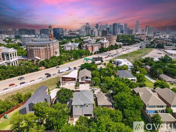 A cityscape with a mix of residential and commercial buildings under a twilight sky.