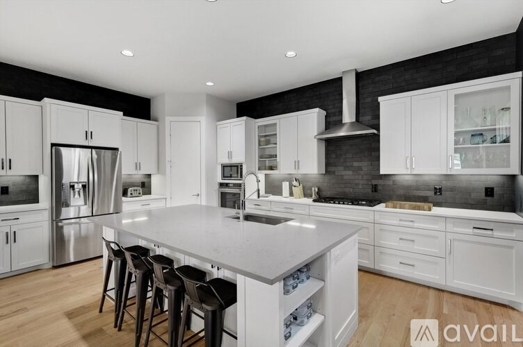 A modern kitchen with white cabinets and a large island.