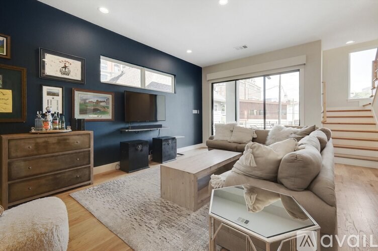 A living room with a dark blue wall and a wooden floor.