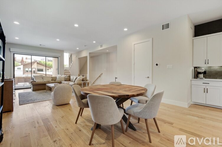 A modern dining room with a wooden table and chairs.