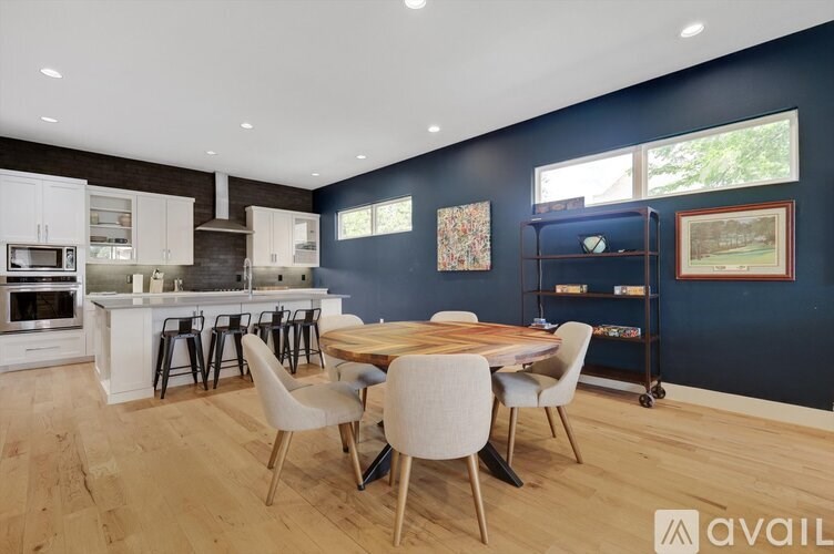 A kitchen with a dining table and chairs.