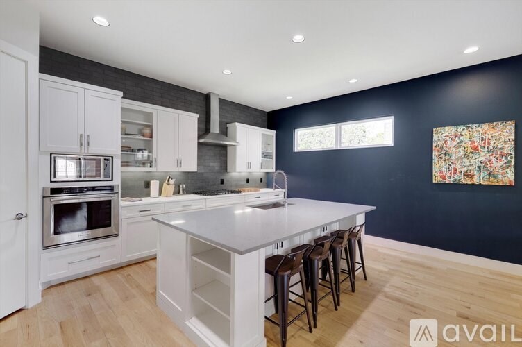 A kitchen with white cabinets and a large island.