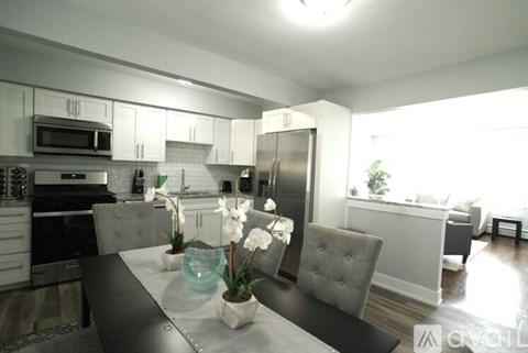 A modern kitchen with a dining table set with flowers.