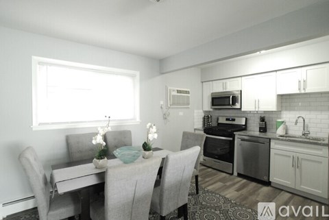 A kitchen with a table and chairs in front of it.