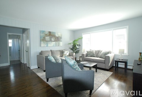A living room with a grey couch and a wooden floor.