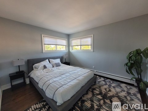 A bedroom with a large bed and a potted plant.