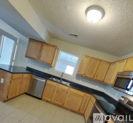 A kitchen with wooden cabinets and a black countertop.