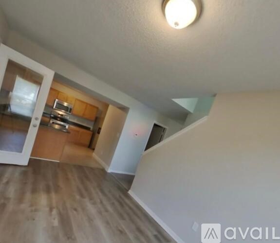 A room with a wooden floor and a white ceiling with a light fixture.