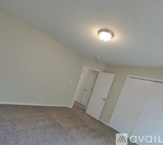 A room with a carpeted floor and a ceiling light.