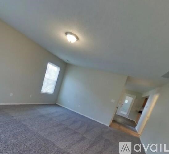 A room with a carpeted floor and a window.