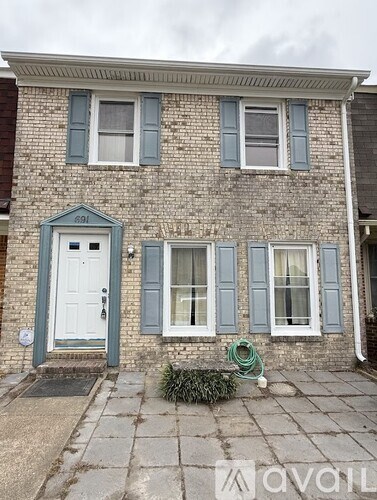 A house with a white door and windows with shutters.