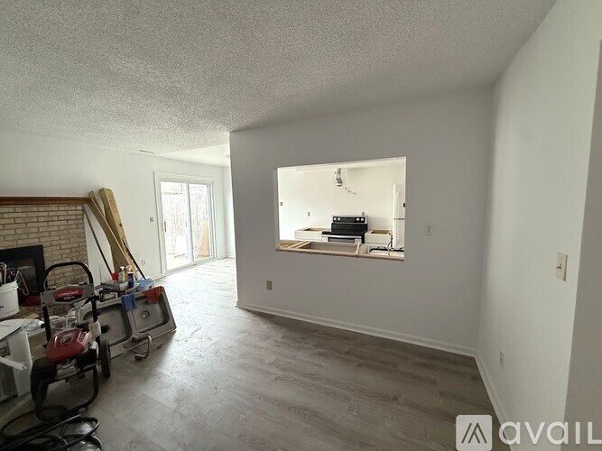 A room with a lot of white walls and a fireplace.