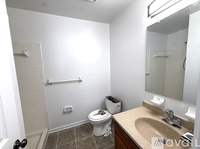 A bathroom with a toilet, sink, mirror, and towel rack.