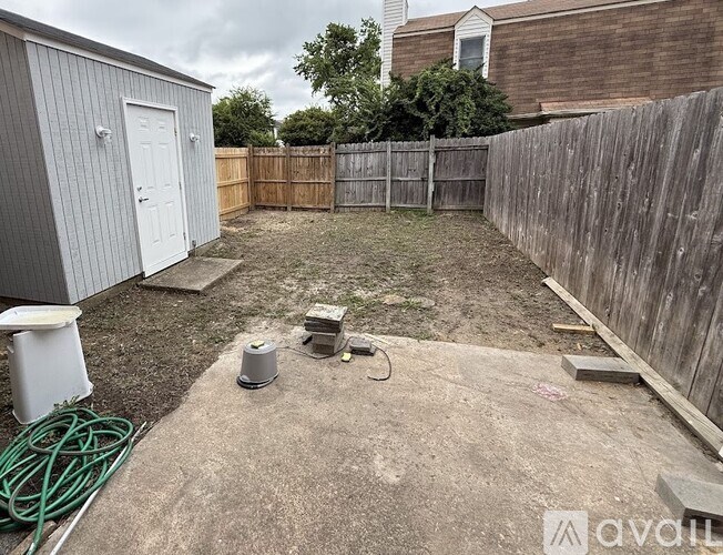 A backyard with a wooden fence and a shed.