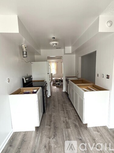 A kitchen with white cabinets and a grey floor.