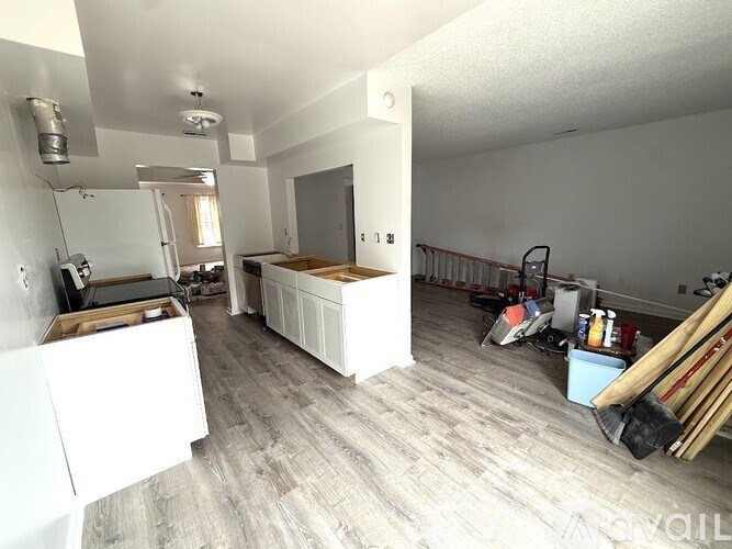 A kitchen with white cabinets and a wooden island in the middle of the room.
