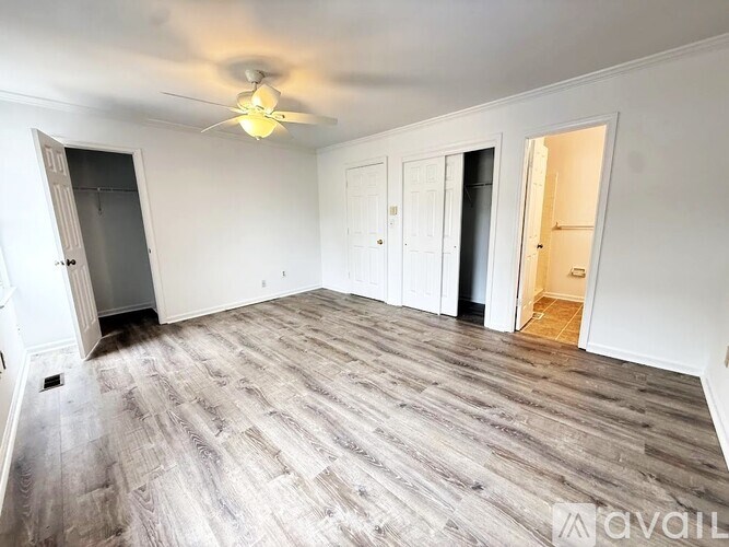 A room with wooden flooring and a window.