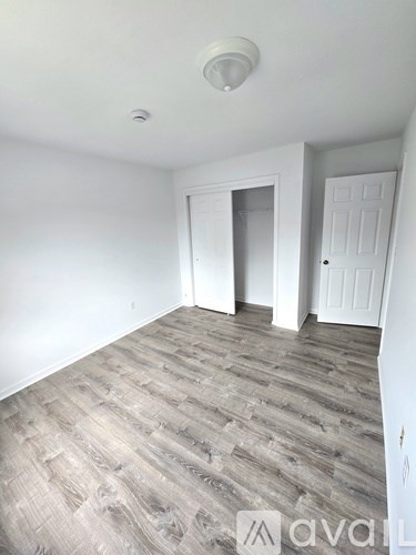 A room with a wooden floor and two white doors.