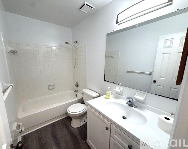 A white bathroom with a toilet, sink, and bathtub.