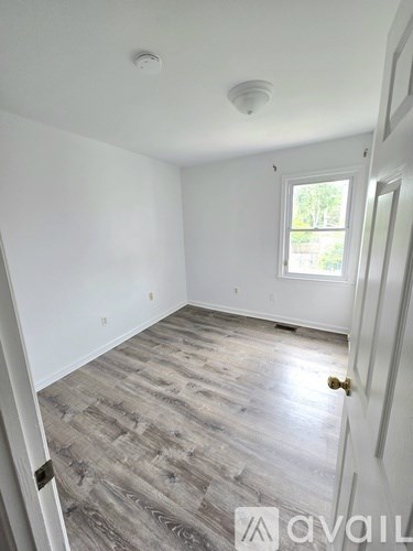 A room with a wooden floor and a window.