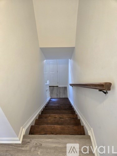 A staircase with wooden steps and a white door at the end.