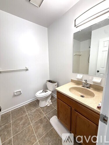 A bathroom with a toilet, sink, and mirror.
