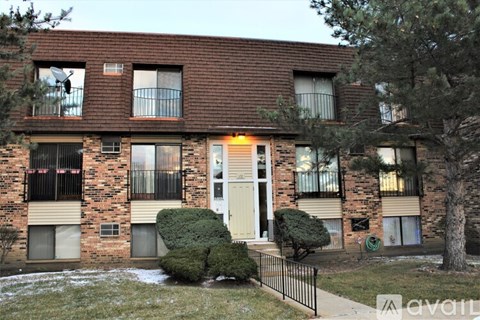 A brick apartment building with a white door and windows.