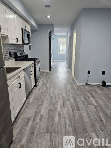 A kitchen with a wooden floor and white cabinets.