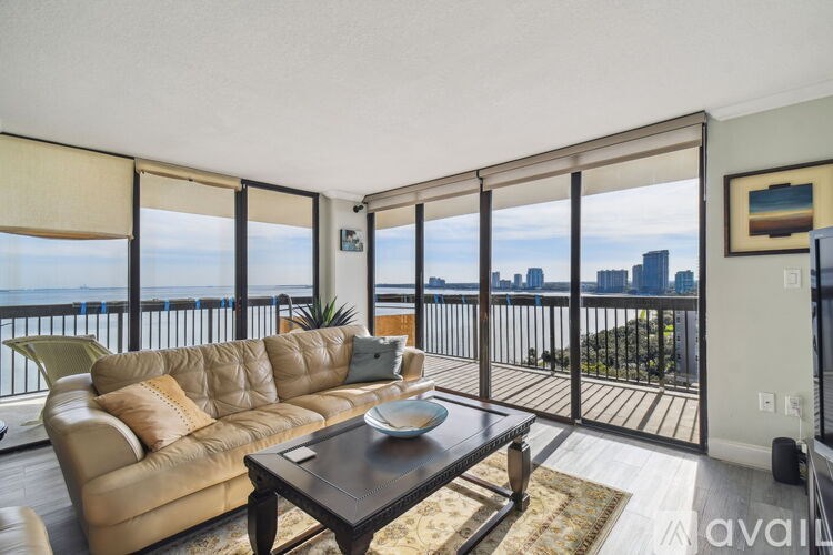 A living room with a large window overlooking a city skyline.
