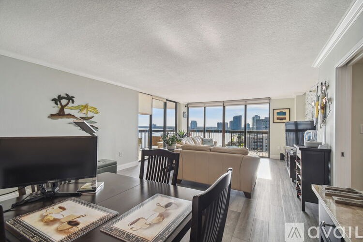 A living room with a television, couch, and a view of the city.