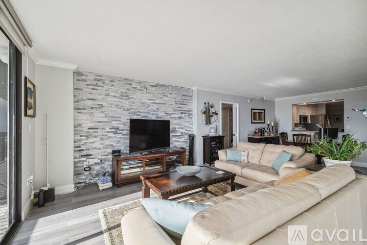 A living room with a stone wall and a television.
