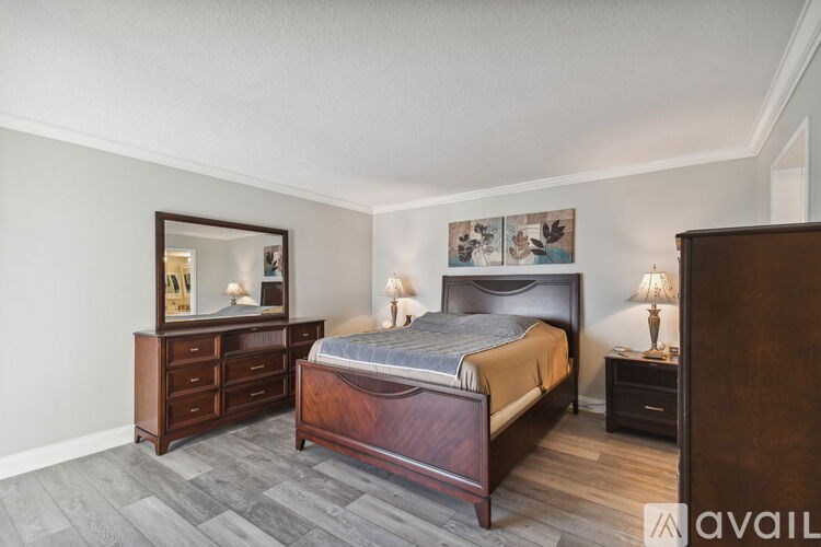 A bedroom with a bed, dresser, and nightstand.
