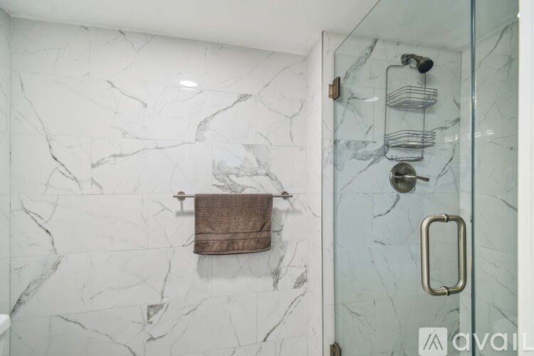 A bathroom with a marble wall and a towel hanging on it.
