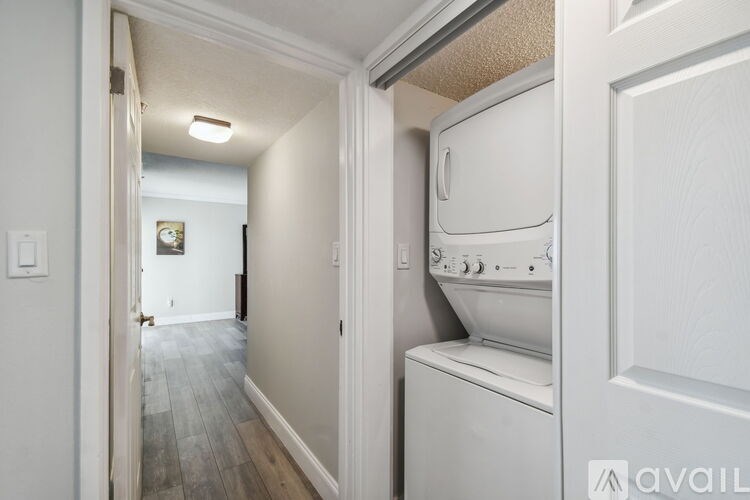 A white dryer is in a small room with a door open.