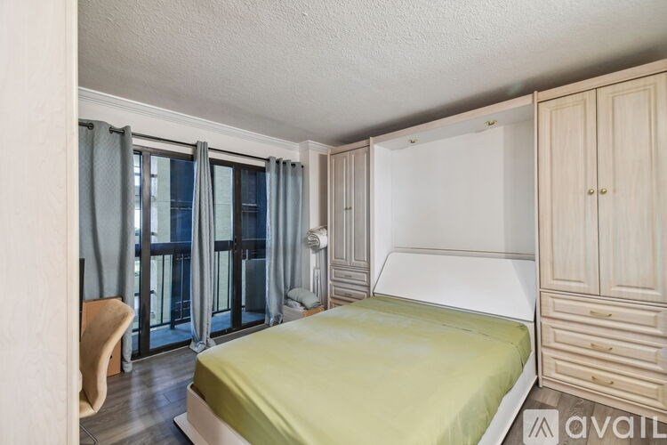 A bedroom with a bed, wardrobe, and chair.