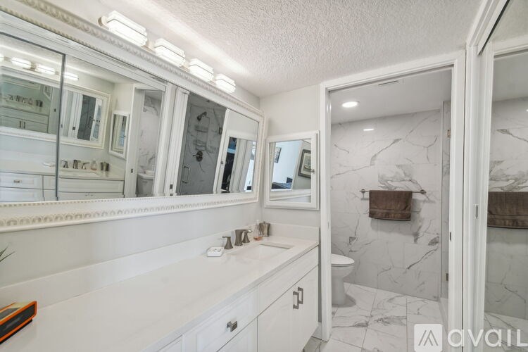 A bathroom with a marble floor and white walls.