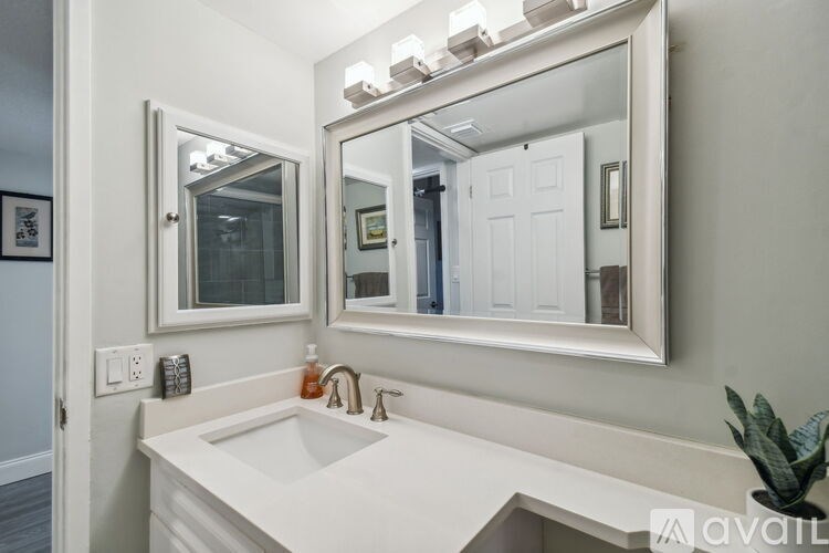 A bathroom with a white sink and a mirror above it.
