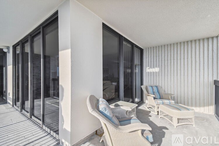 A patio with a white couch and chairs is shown.