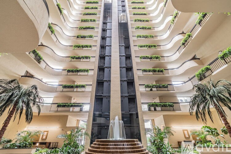 A tall building with a fountain in the middle of a staircase.