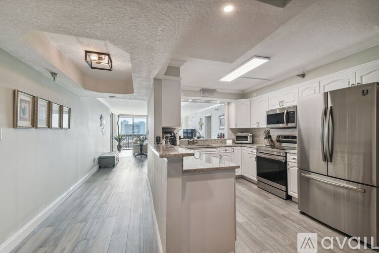 A kitchen with a refrigerator, oven, and sink.