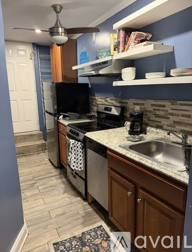 A kitchen with a black fridge, a black dishwasher, a black oven, a black microwave, a black stove, a black sink, a black counter, a black fan, a black cabinet, a black