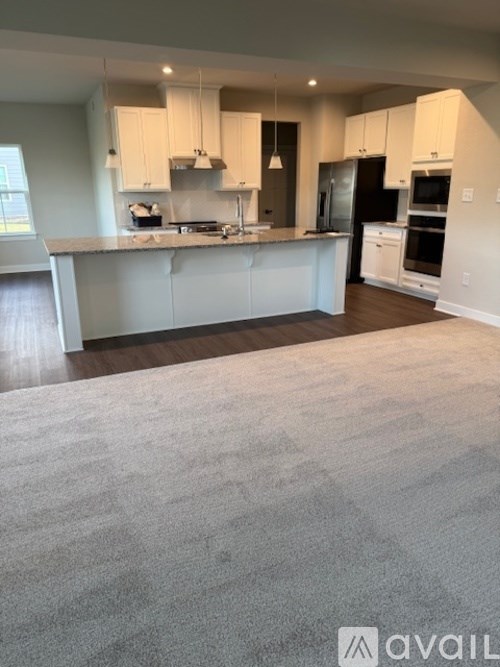 A kitchen with white cabinets and a large island.